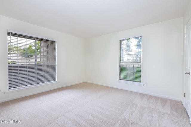 empty room featuring carpet flooring and baseboards