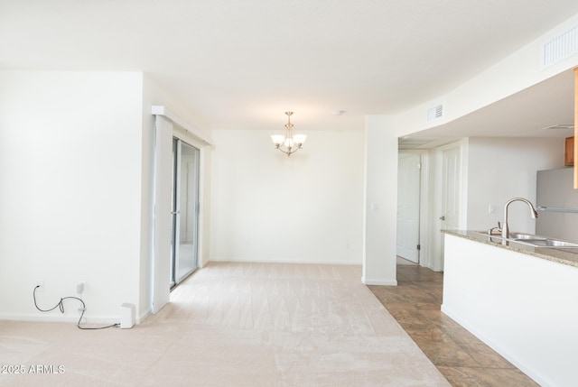 interior space featuring visible vents, baseboards, an inviting chandelier, and a sink