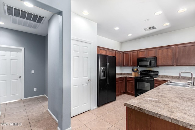 kitchen featuring light tile patterned flooring, sink, and black appliances