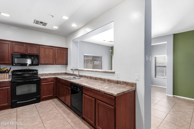 kitchen featuring black appliances, sink, and light tile patterned floors