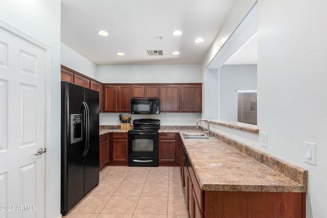 kitchen featuring black appliances, kitchen peninsula, sink, and light tile patterned floors