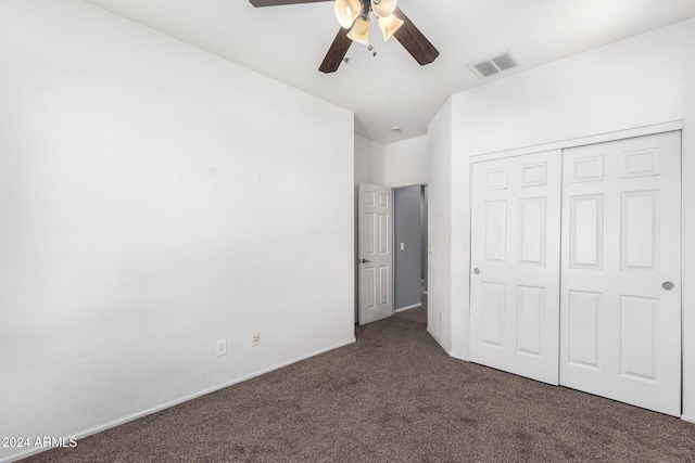 unfurnished bedroom featuring ceiling fan, dark colored carpet, and a closet