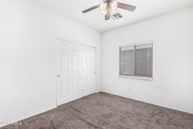 unfurnished bedroom featuring carpet, ceiling fan, and a closet