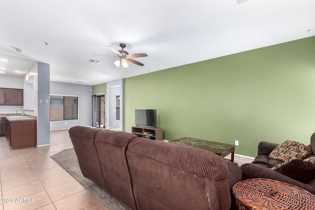 living room with ceiling fan, sink, and light tile patterned flooring