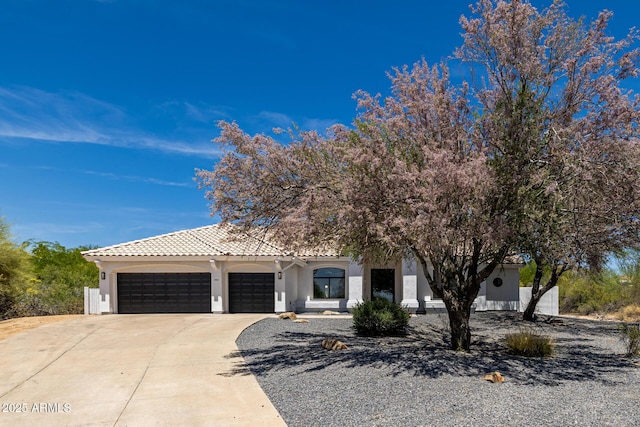 8156 E Questa Rd, Scottsdale, AZ 85255 - view of property hidden behind natural elements with stucco siding, an attached garage, concrete driveway, and a tile roof
