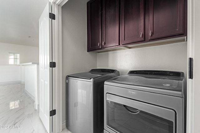 laundry room with washer and dryer and cabinets