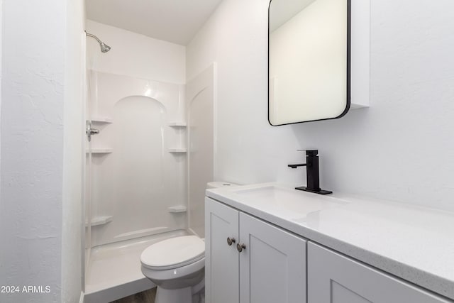 bathroom with vanity, toilet, and walk in shower