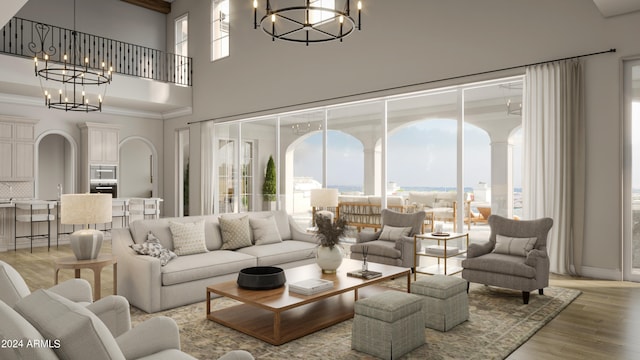 living room with a high ceiling, a notable chandelier, and light wood-type flooring