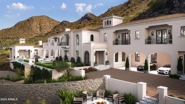 view of front of property with a mountain view and an outdoor fire pit