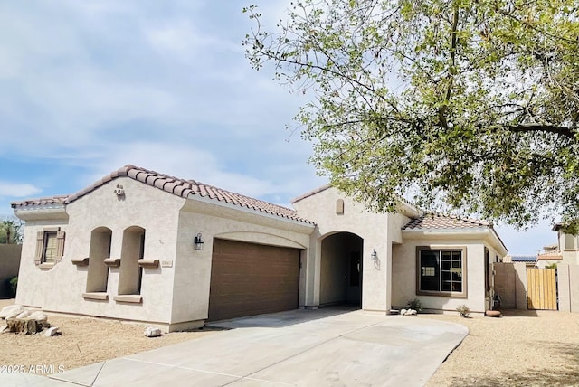 17496 W Papago St, Goodyear, AZ 85338 - mediterranean / spanish house with stucco siding, an attached garage, a tiled roof, and concrete driveway