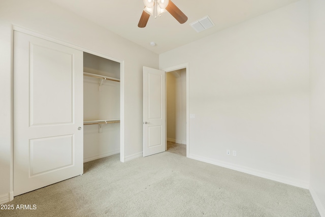 unfurnished bedroom featuring light colored carpet, ceiling fan, and a closet