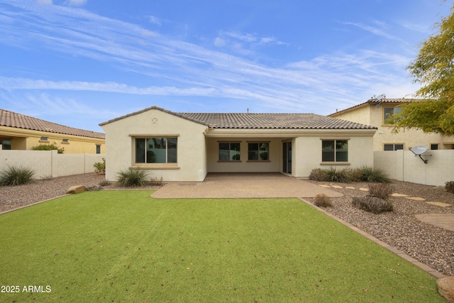 back of property with a yard and a patio