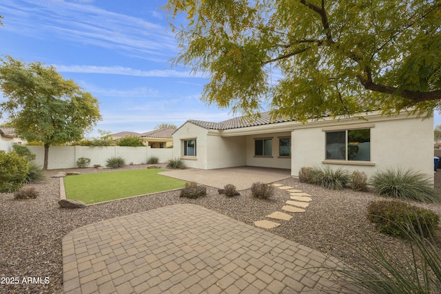 back of house with a patio area and a lawn