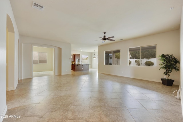 unfurnished living room featuring light tile patterned flooring and ceiling fan