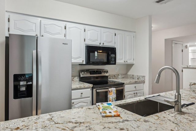 kitchen featuring a sink, stainless steel appliances, light stone counters, and white cabinetry