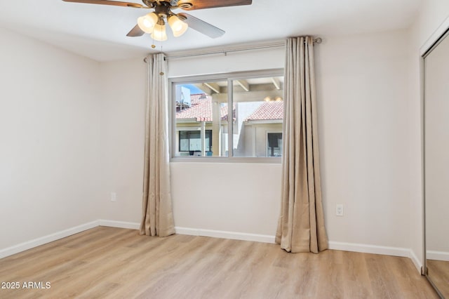 empty room featuring a ceiling fan, baseboards, and wood finished floors