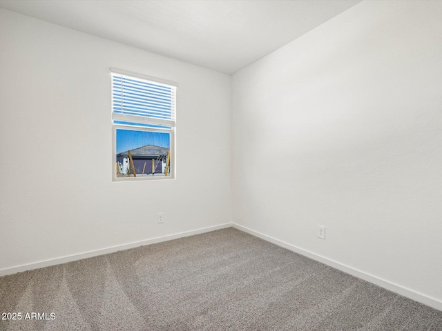 carpeted spare room with baseboards