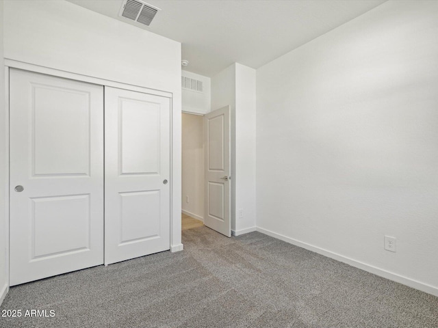 unfurnished bedroom with carpet floors, a closet, visible vents, and baseboards