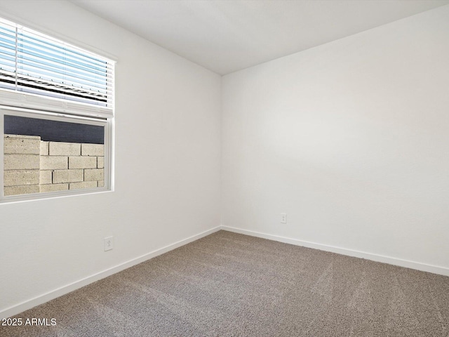 carpeted spare room with baseboards