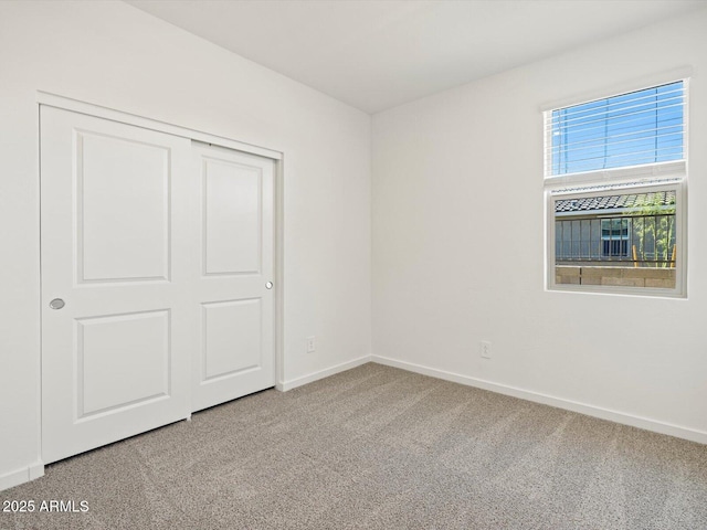 unfurnished bedroom featuring a closet, carpet flooring, and baseboards