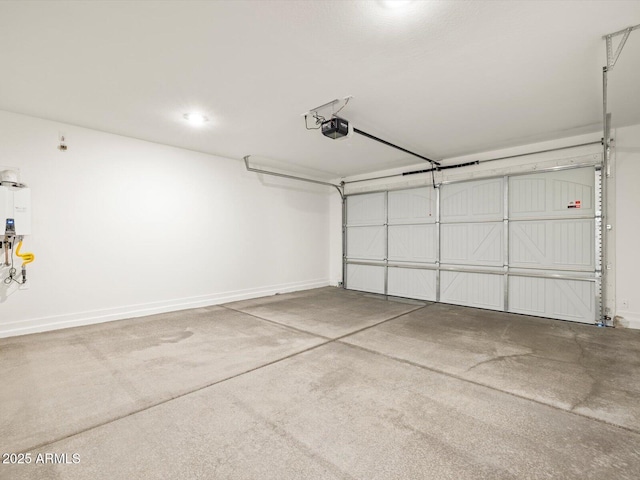 garage featuring baseboards, tankless water heater, and a garage door opener