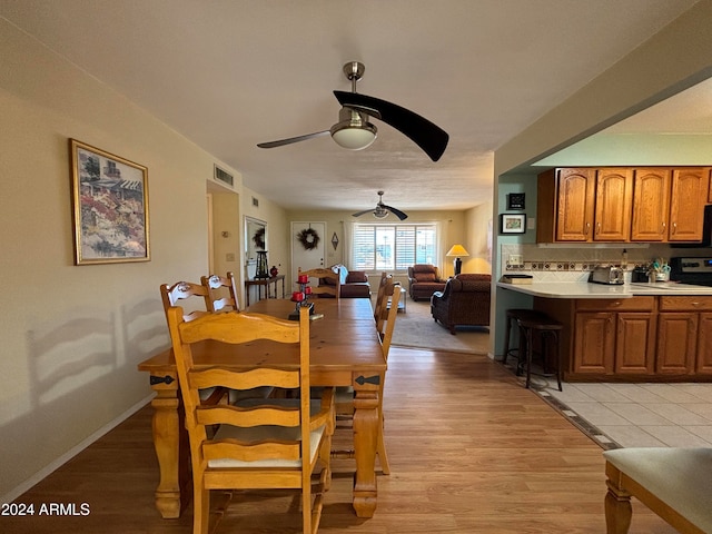 dining room with ceiling fan and light wood-type flooring