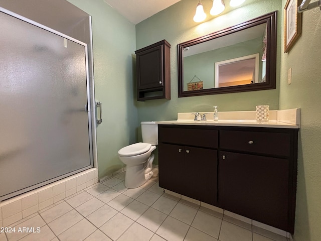 bathroom with vanity, a shower with shower door, tile patterned flooring, and toilet