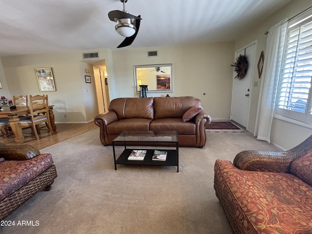 carpeted living room featuring ceiling fan