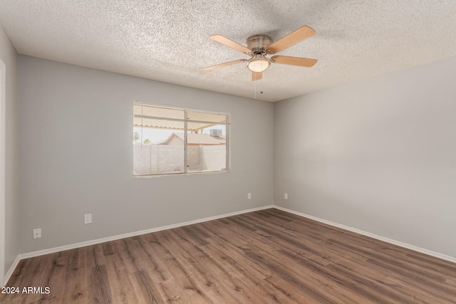 unfurnished room featuring ceiling fan, a textured ceiling, and dark wood-type flooring