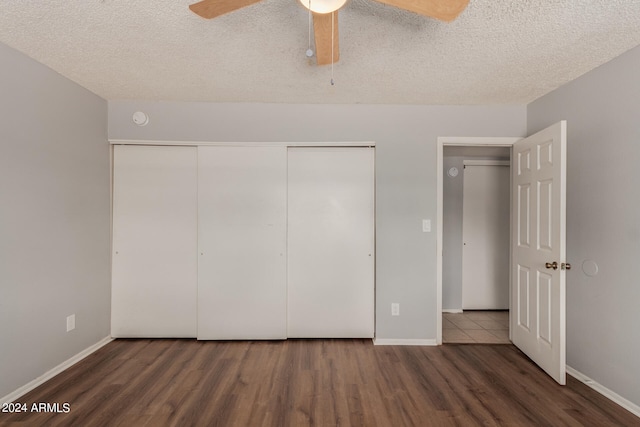 unfurnished bedroom featuring ceiling fan, dark wood-type flooring, and a textured ceiling