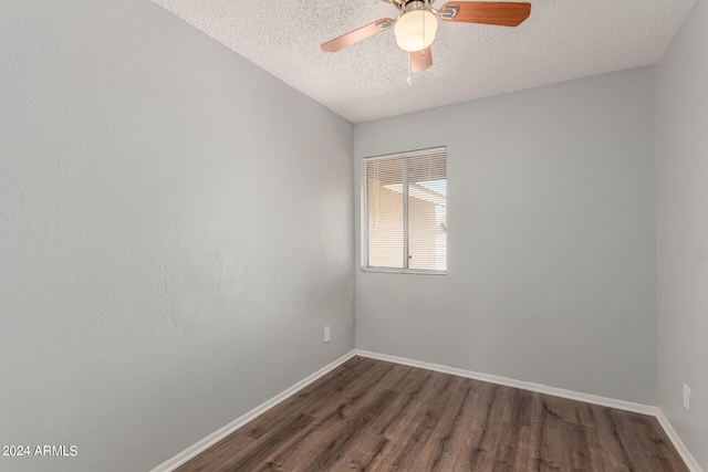 empty room featuring ceiling fan, dark wood-type flooring, and a textured ceiling