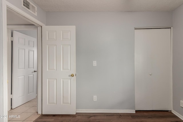 unfurnished bedroom featuring a textured ceiling and hardwood / wood-style floors