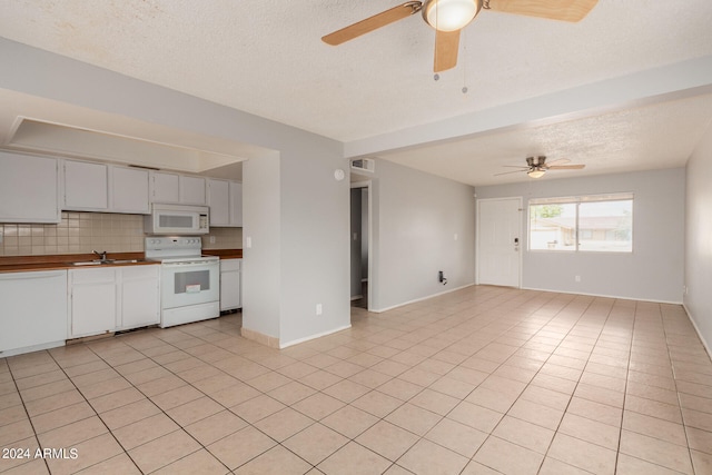 kitchen featuring ceiling fan, light tile patterned flooring, sink, white appliances, and tasteful backsplash