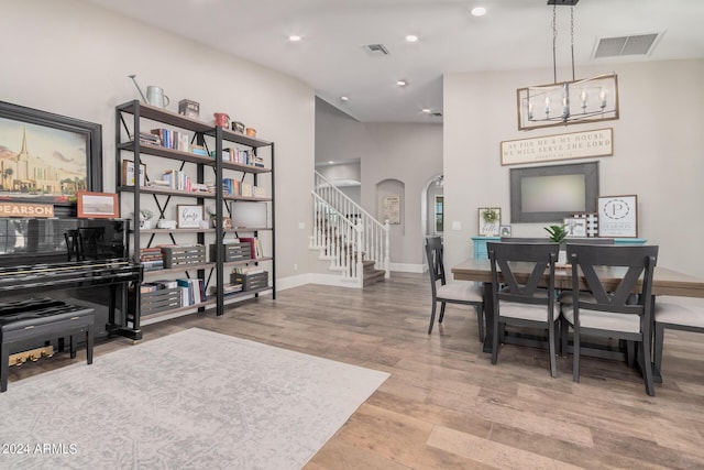 dining space with wood finished floors, visible vents, recessed lighting, arched walkways, and stairs