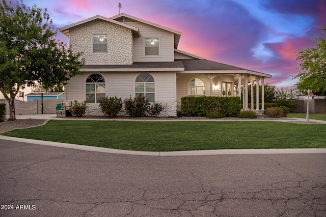 view of front of house with a yard and fence