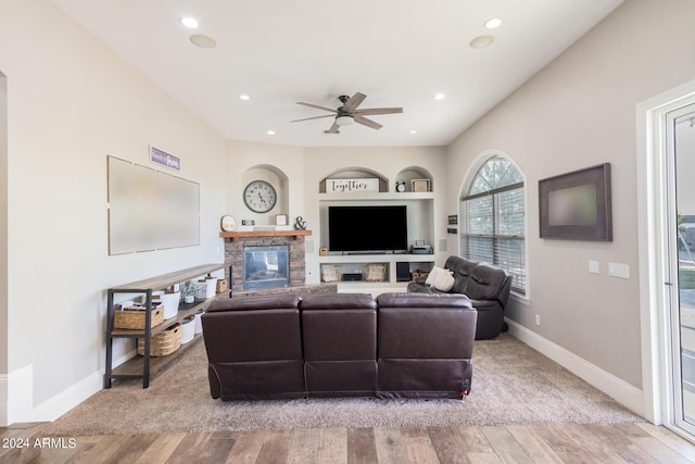 living room with recessed lighting, a fireplace, baseboards, and wood finished floors