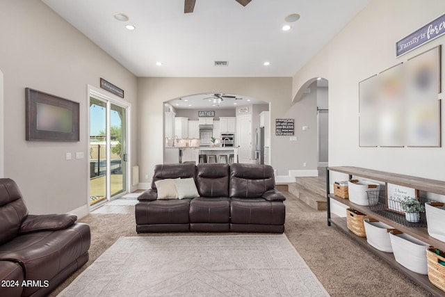 living room with visible vents, a ceiling fan, recessed lighting, arched walkways, and baseboards