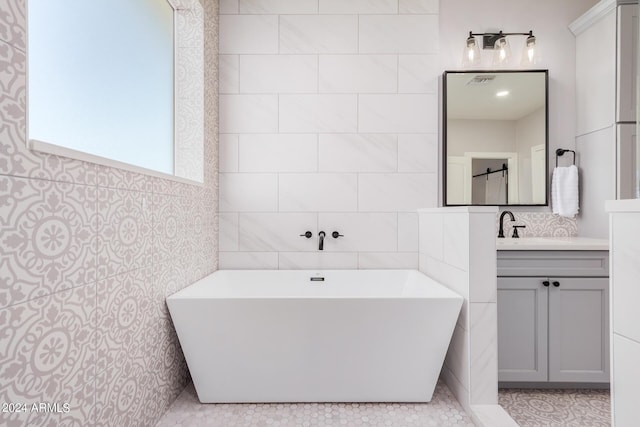 bathroom with vanity, tile walls, and a freestanding bath