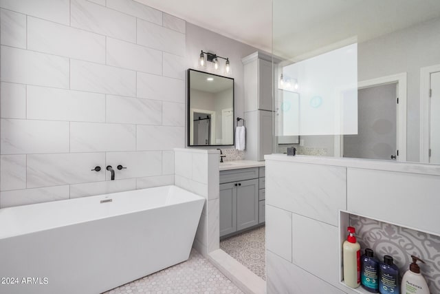 full bath featuring tile patterned floors, a soaking tub, tile walls, and vanity