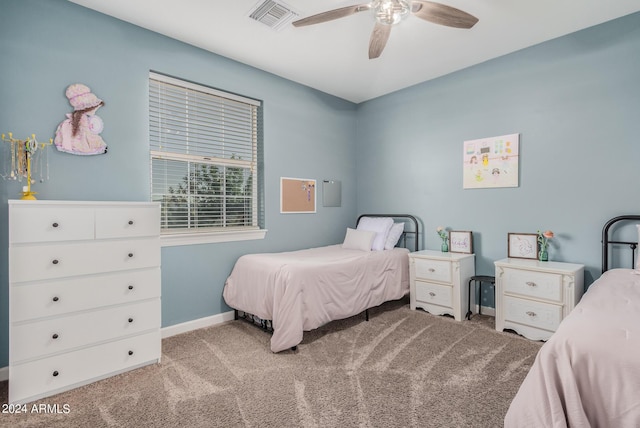 carpeted bedroom with visible vents, baseboards, and ceiling fan