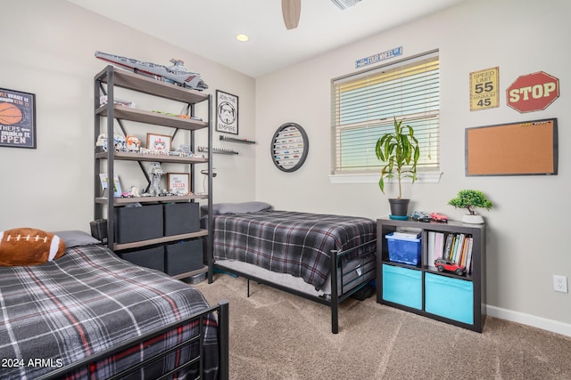 carpeted bedroom with visible vents, baseboards, and ceiling fan