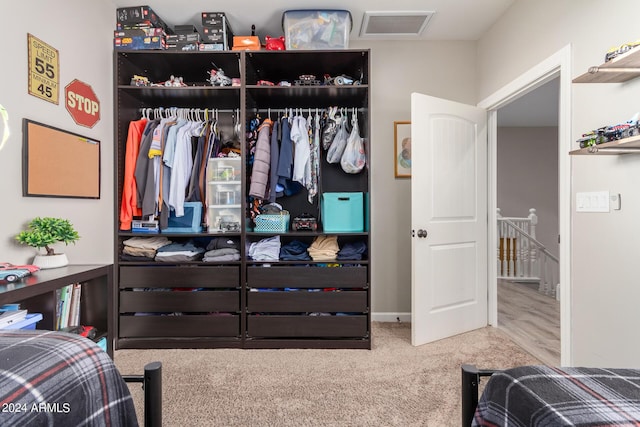 carpeted bedroom with visible vents and a closet