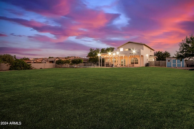 view of yard with an outbuilding, a patio, a storage unit, and a fenced backyard