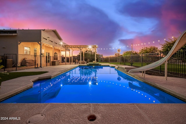 pool at dusk with a fenced in pool, a water slide, a fenced backyard, a pergola, and a patio