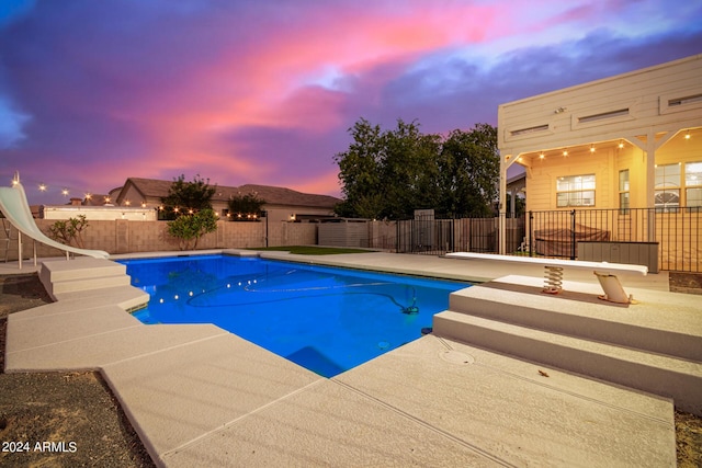 view of swimming pool featuring a fenced in pool, a patio, a water slide, and a fenced backyard