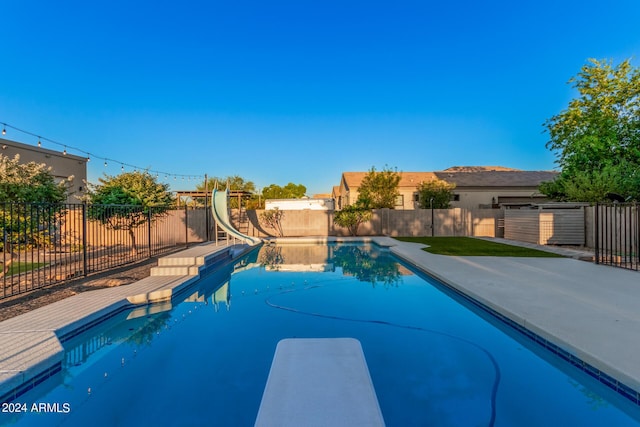 view of swimming pool featuring a fenced backyard, a fenced in pool, and a water slide