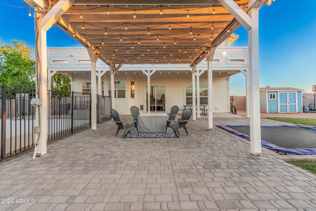 view of patio featuring a storage shed, fence, and an outdoor structure