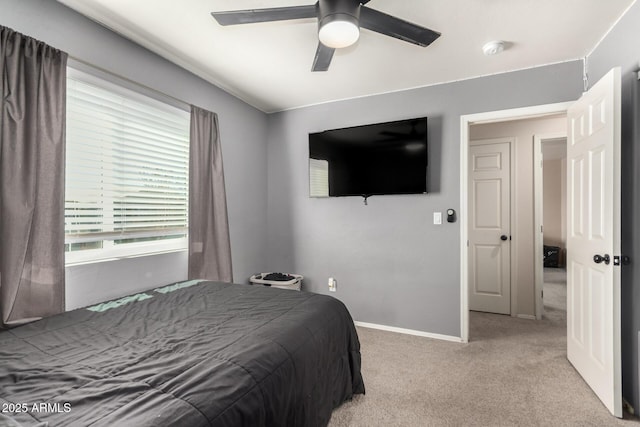 bedroom with light carpet, ceiling fan, and baseboards