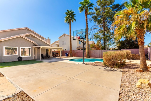 view of sport court with basketball hoop, a fenced backyard, and a fenced in pool