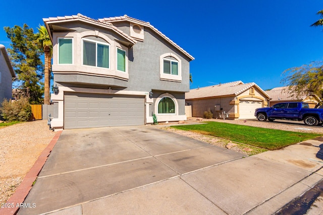 view of front of home with a garage, concrete driveway, a tiled roof, fence, and stucco siding